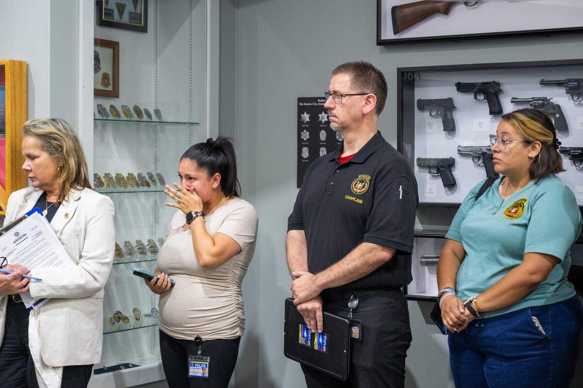 Officers with the KCK Police Department stand and grieve as Chief of Police Karl Oakman speaks to the media following the death of KCKPD officer Hunter Simoncic, on Tuesday, Aug. 26, 2025, at KCKPD Headquarters.