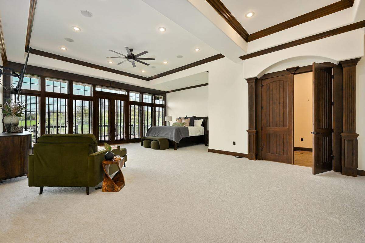 The primary suite inside 33901 E. Colbern Road in Lone Jack, Missouri takes over an entire wing of the home. The suite includes a sitting room and office space, a walk-in closet, an en-suite laundry room, a kitchenette, bar and a wide view of the estate.