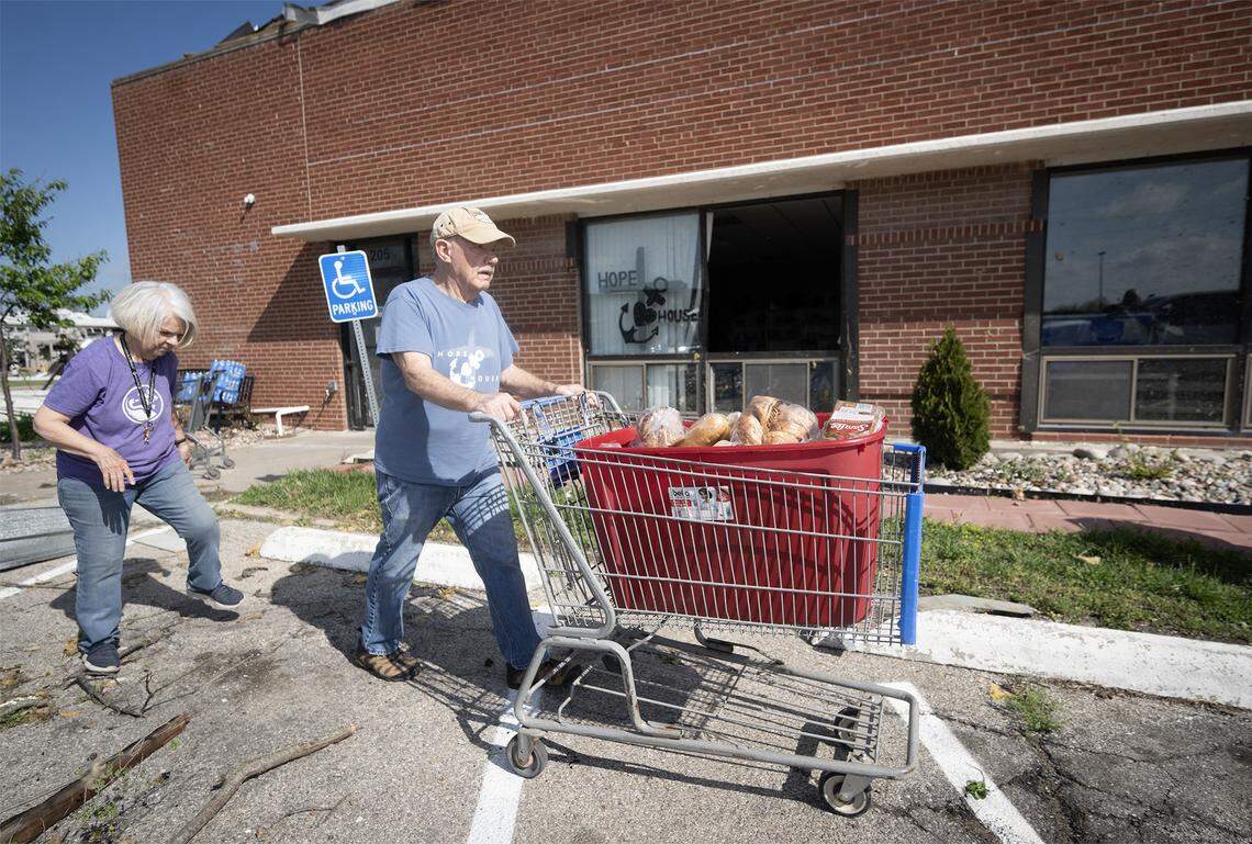 Roger Carson and Janet Slifer moved perishable items from Hope House, a not-for-profit food pantry, in Franklin County, Kansas, on Tuesday, April 14, 2026, in Ottawa, Kansas. A tornado struck the facility Monday night and damage the building. 