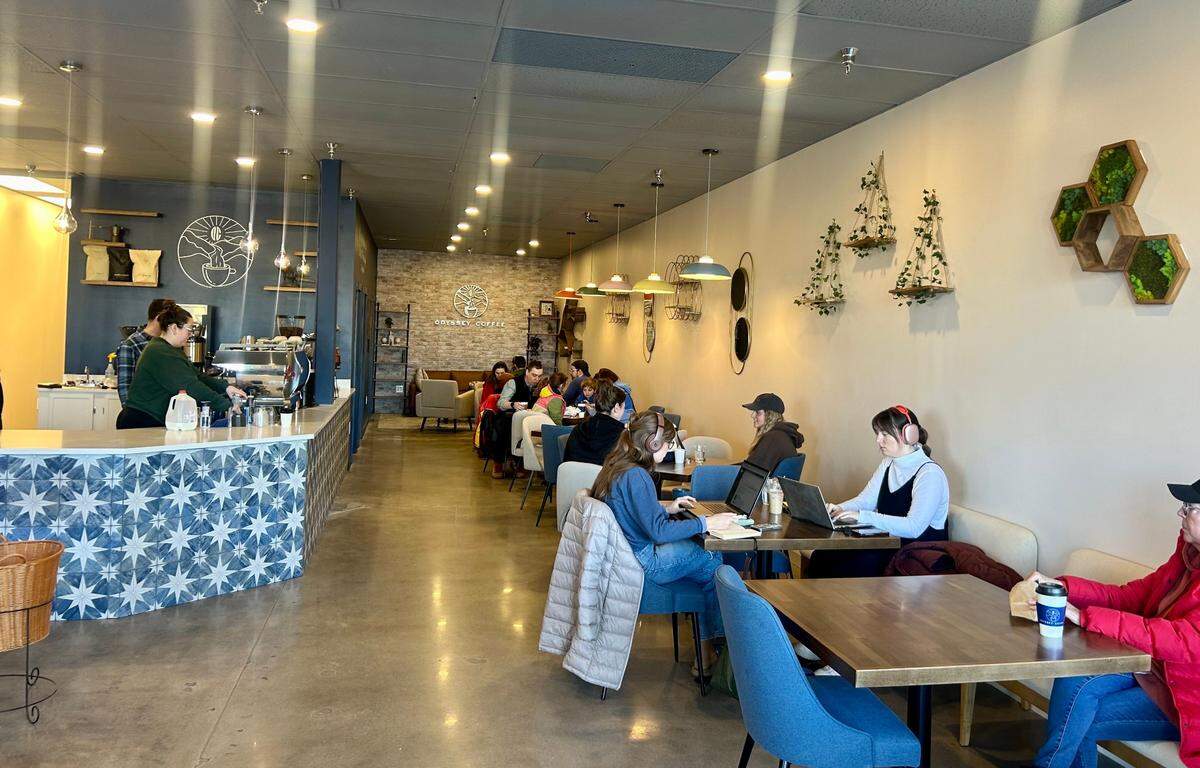 Customers sipped espresso drinks inside Odyssey Coffee on its opening day Monday.