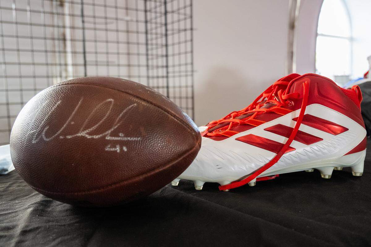 A signed football and a pair of Chris Jones' cleats for sale at The Pavilion at GEHA Field at Arrowhead Stadium on Friday, February 20, 2026. Fans can come and shop on Saturday for items such as game worn jerseys, practice gear, and cleats.