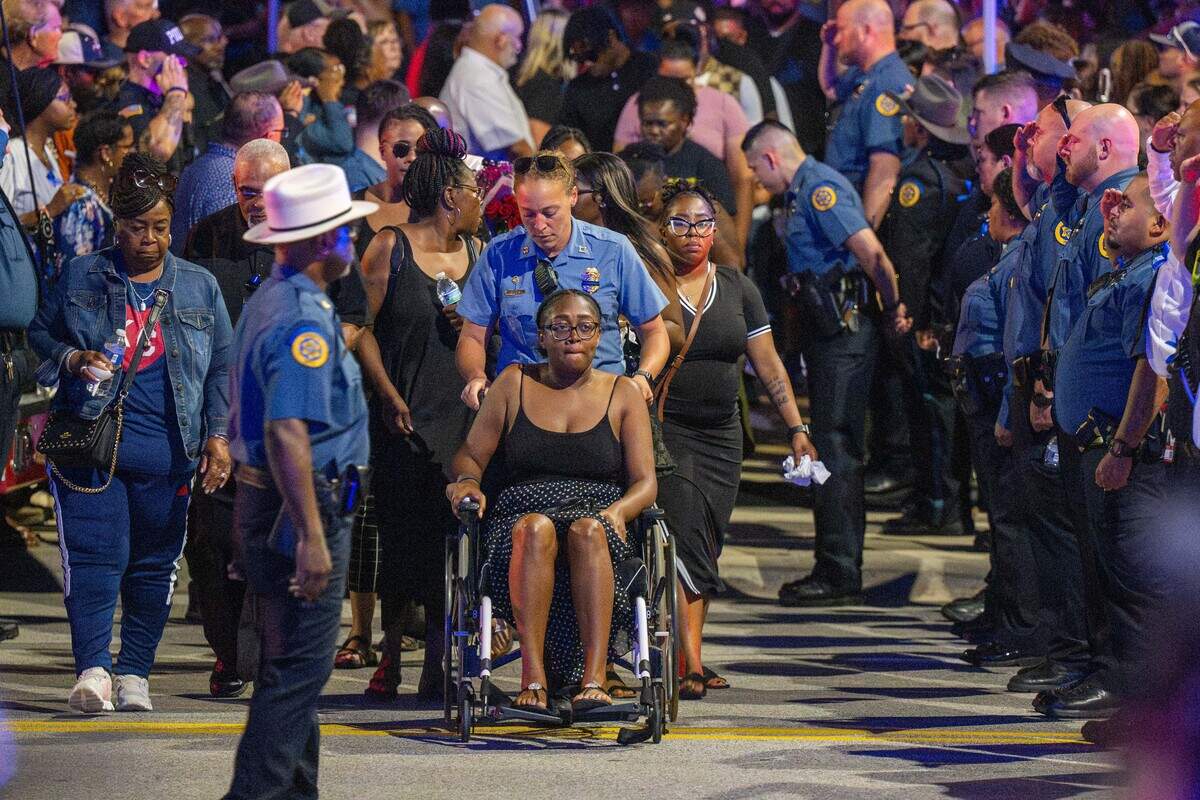 Members of slain Wyandotte County sheriff’s deputy Elijah Ming’s family move through rows of saluting law enforcement officers outside the Wyandotte County Courthouse following a candlelight vigil for Ming on Wednesday.