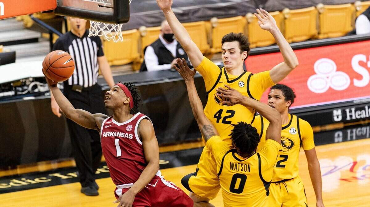 Arkansas’ JD Notae, left, shoots as he drives past Missouri’s Torrence Watson, bottom, Dru Smith, right, and Parker Braun, top, during the first half of an NCAA college basketball game Saturday, Feb. 13, 2021, in Columbia, Mo. (AP Photo/L.G. Patterson)