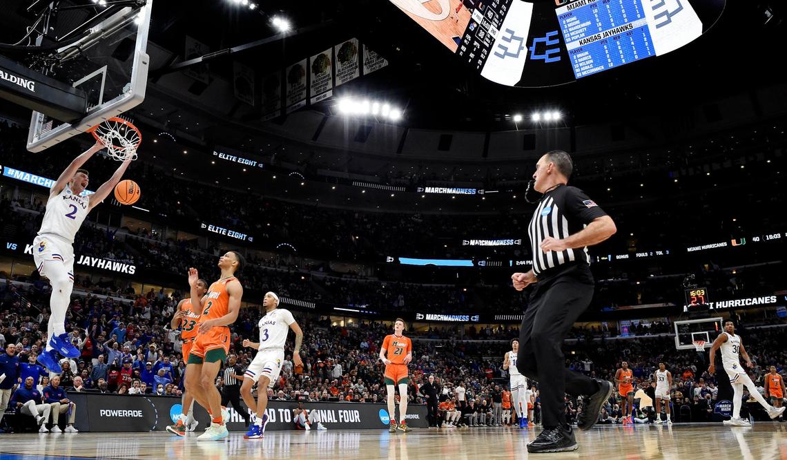 KU’s Christian Braun threw down a dunk over Miami’s Kameron McGusty during the second half of the NCAA Midwest Regional championship game Sunday at the United Center in Chicago. KU beat Miami 76-50 to advance to the Final Four.