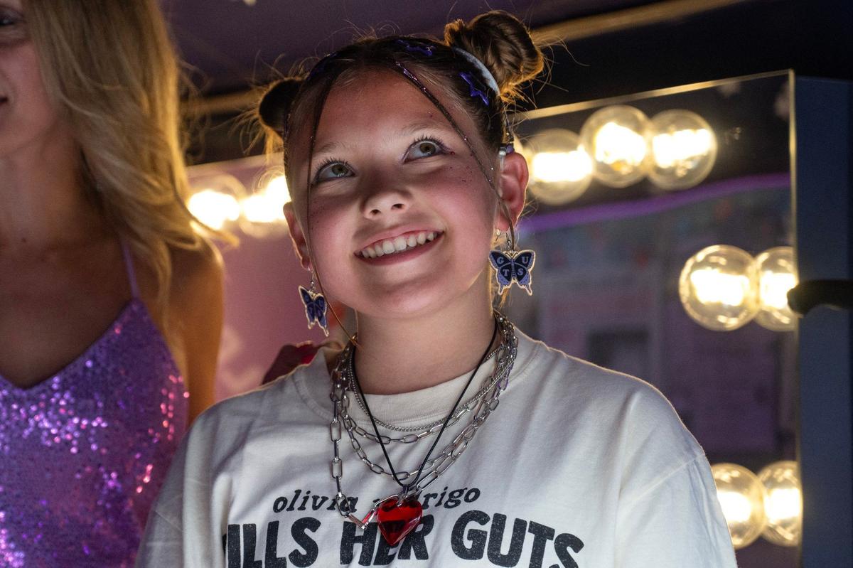 Riley Tann looks up while visiting an interactive bus exhibit for the Olivia Rodrigo Guts World Tour concert outside T-Mobile Center on Friday, July 26, 2024, in Kansas City.
