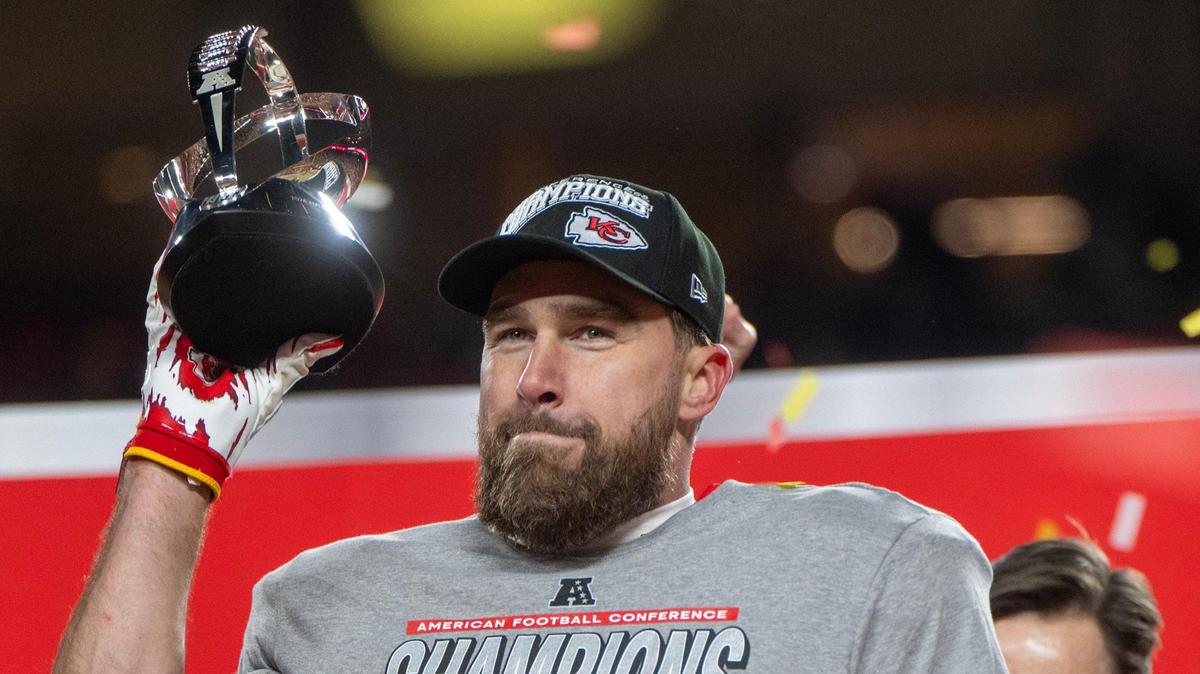 Chiefs tight end Travis Kelce holds the Lamar Hunt Trophy, as the team celebrates a 32-29 victory over the Buffalo Bills to secure the AFC Championship on Sunday, Jan. 26, 2025, at GEHA Field at Arrowhead Stadium.