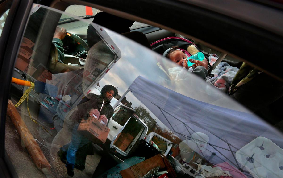 Pam Bryant feeds her granddaughter Jream Jordan, 7 months, as Emmett Jefferson brings milk to their car during a weekly food giveaway for children in the 4100 block of North Grand Boulevard. The non-profit Seeds of Substance provided enough food for 750 children to be fed for a week. Ward 3 committeewoman Lucinda Frazier said that addressing hunger is one issue that can lead to a reduction in gun violence. “Hunger, poverty, lack of good paying jobs and lack of education - all of these things go hand-in-hand,” she said.
