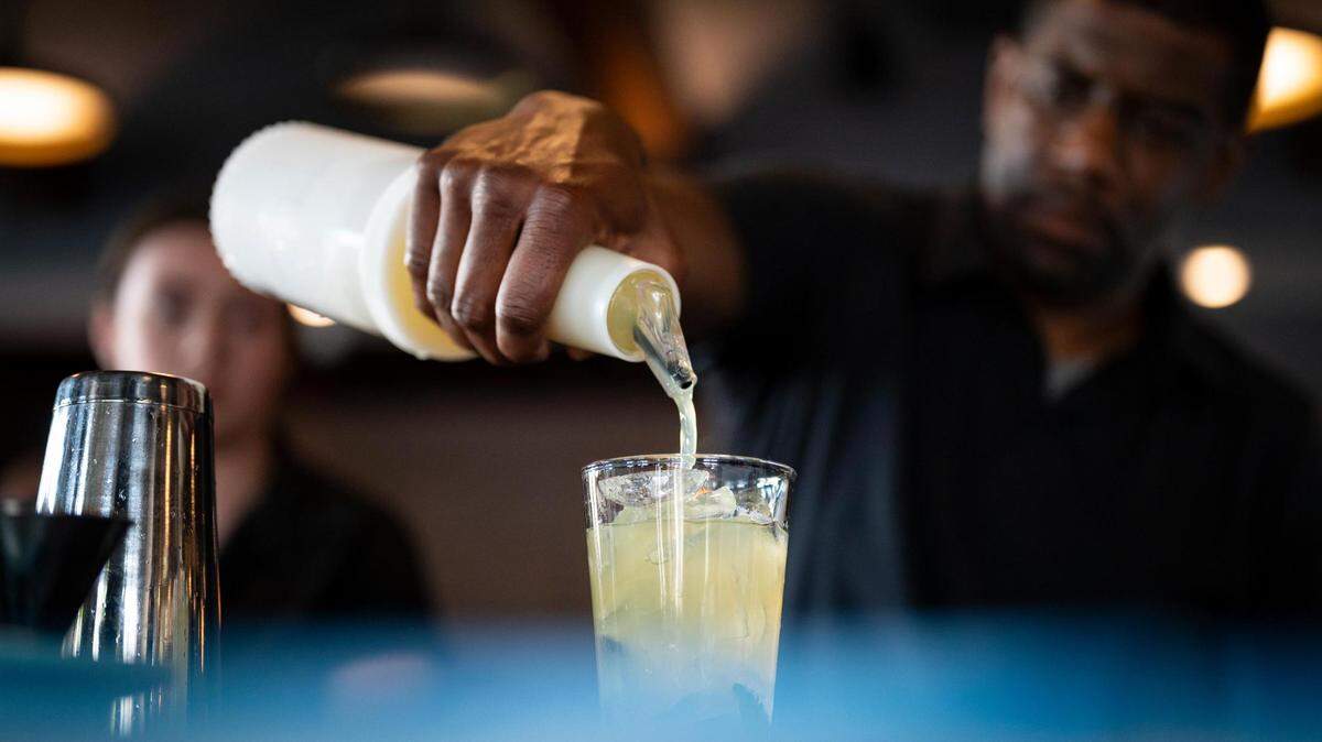 During a preopening event, bartender Caleb Keith pours a drink as Emily Vosburg stands by at Briarcliff Barrio, a Mexican Kitchen + Bar.