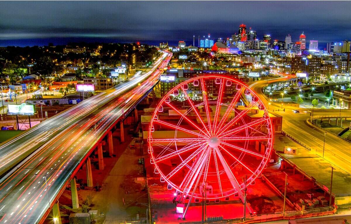 A 150-foot tall Ferris wheel called KC Wheel glows in the night near  Pennway Point, a stalled entertainment district that was being developed by 3D Development of Kansas City.