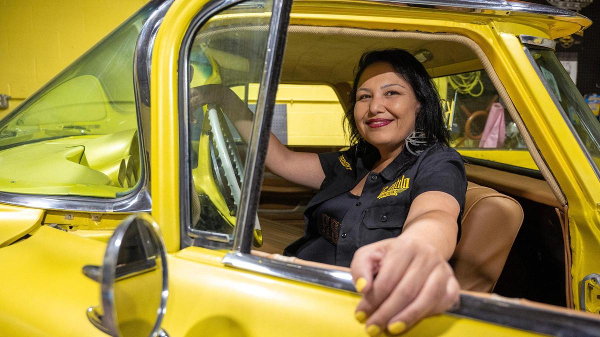 Monica Pena, the first female president of the KC Estilo Car Club, has honored fallen members of the local lowrider community with a Dia de los Muertos altar in the trunk of her 1948 Chevy Stylemaster coupe. Here, the car buff is seen in her 1959 El Camino Chevy.