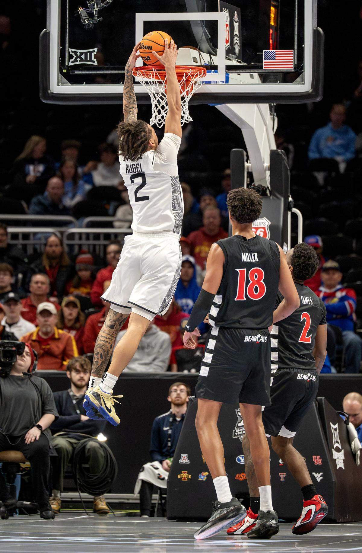 UCF Knights guard Riley Kugel (2) makes a slam dunk during the first half of a Big 12 Men's Basketball Tournament game against the Cincinnati Bearcats at T-Mobile Center on Wednesday, March 11, 2026, in Kansas City.