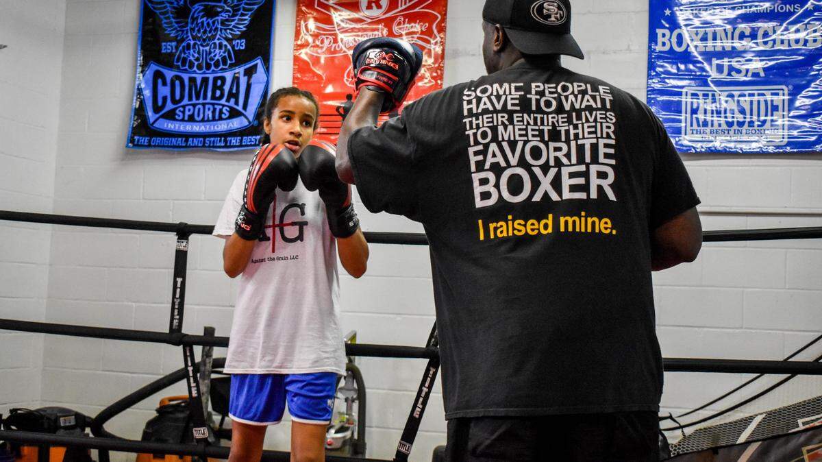 Brijhana Epperson, left, works out with her dad, Courtney, in the boxing ring during a recent training session.
