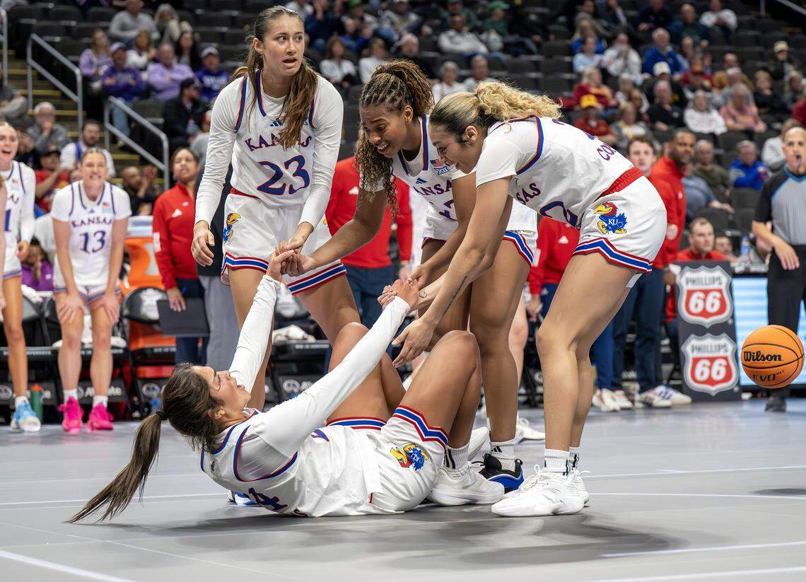 Kansas Jayhawks teammates help forward Regan Williams (24) after she was fouled during the second quarter against the UCF Knights in the Big 12 Women's Basketball Tournament at T-Mobile Center on Wednesday, March 4, 2026, in Kansas City.