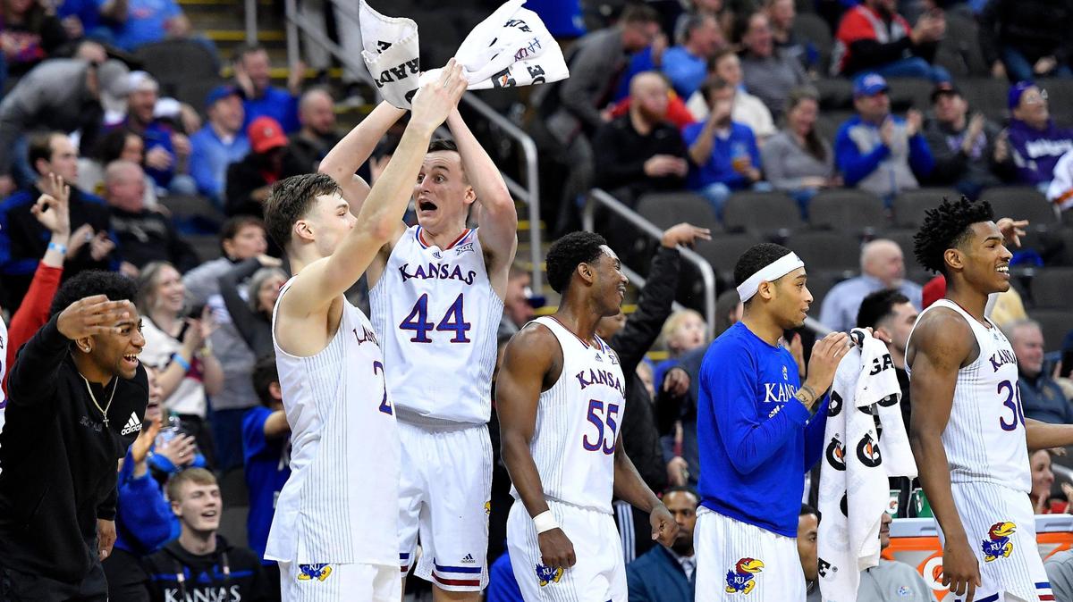 The KU bench reacts to teammate Chris Teahan’s three-pointer during the second half of Thursday’s Big 12 Tournament game at the T-Mobile Center in Kansas City. KU beat West Virginia, 87-63.