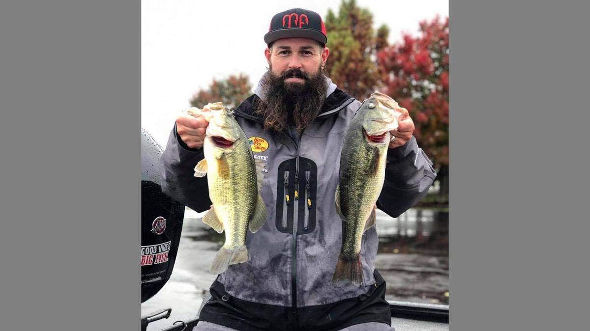 Angler Eddie Brown hoists two great fall bass from a Lee’s Summit lake. The fall colors are looking good.