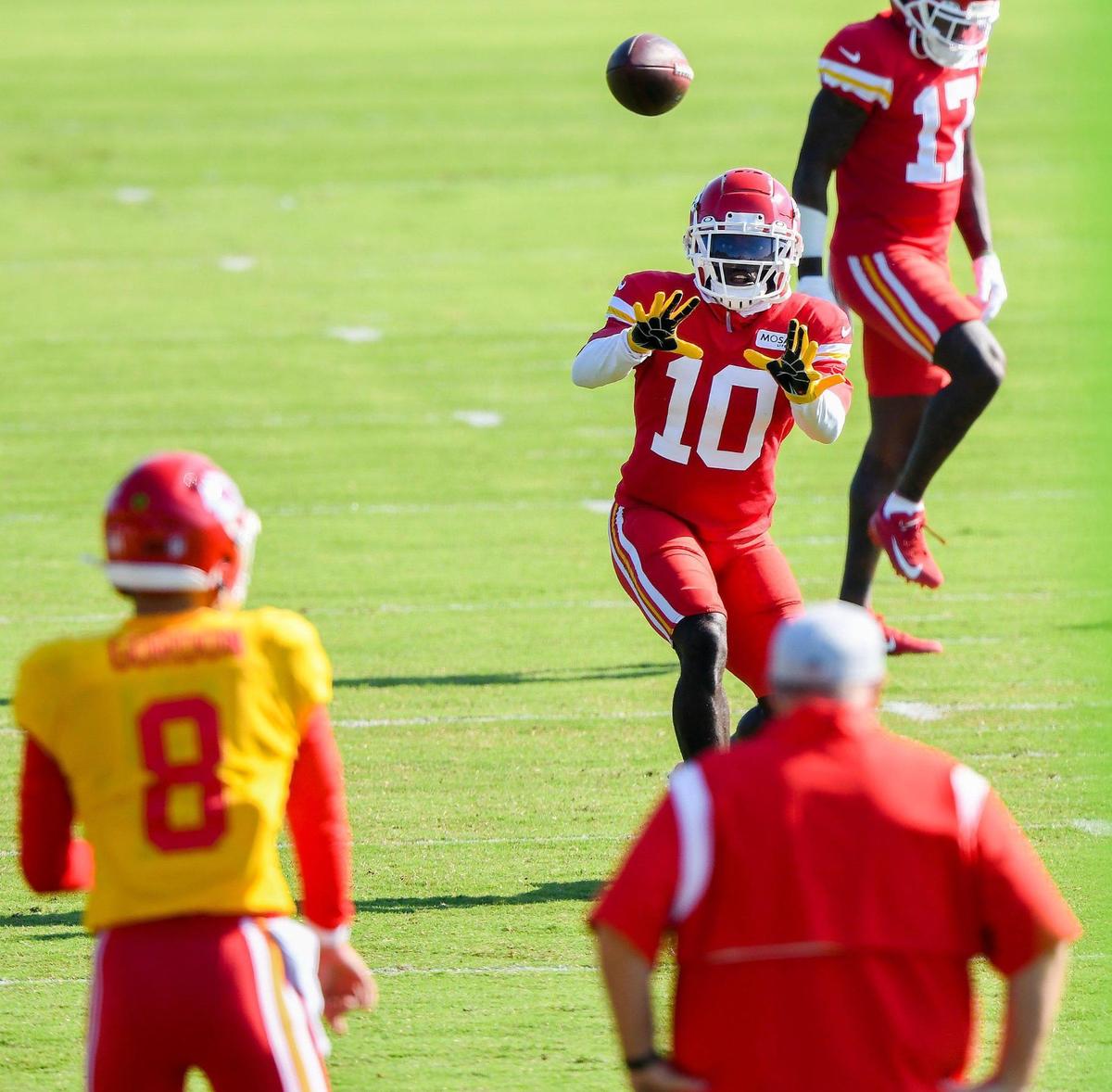Wide receiver Tyreek Hill makes a catch from backup quarterback Anthony Gordon (8) as head coach Andy Reid watches during Kansas City Chiefs training camp at Missouri Western State University in St. Joseph Tuesday, Aug. 17, 2021.
