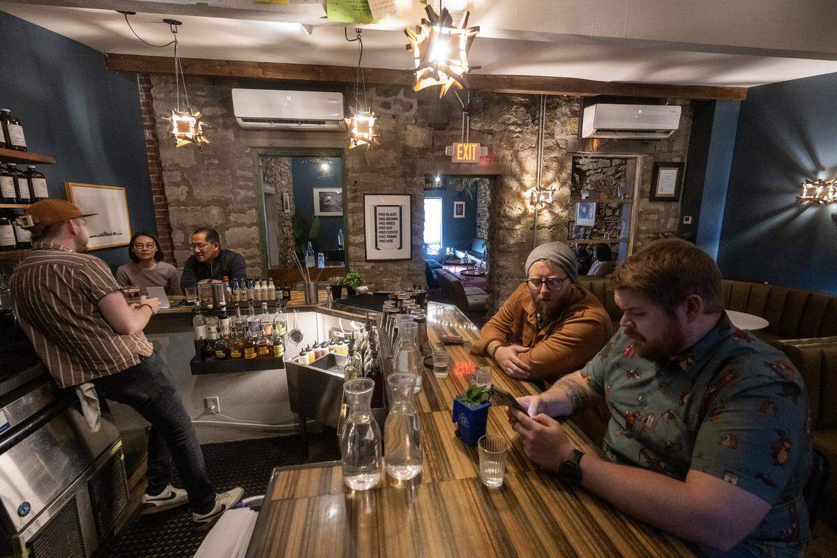 Nate Tallman, left, bar manager at Drastic Measures in downtown Shawnee, talks with customers on Thursday, March 12, 2026. The bar is again up for a James Beard Award in the Outstanding Bar category.
