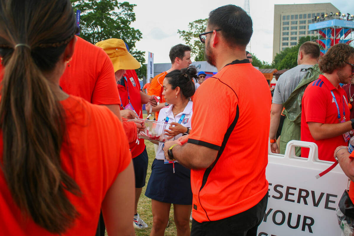 A Bank of America employee hands out wristbands for the next time slot to get fan bands.