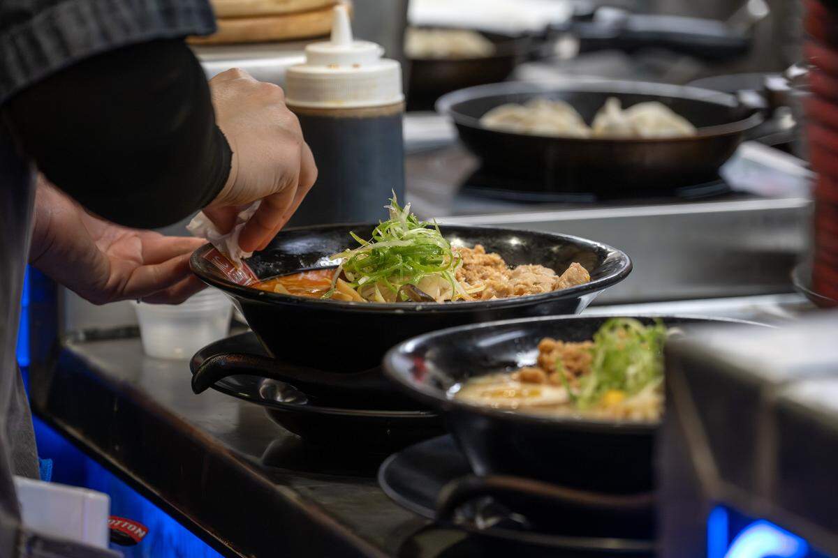 Rika Nakajima wipes the rim of a bowl to clean it before serving an order at KC Craft Ramen on Wednesday, Oct. 29, 2025, in Overland Park.