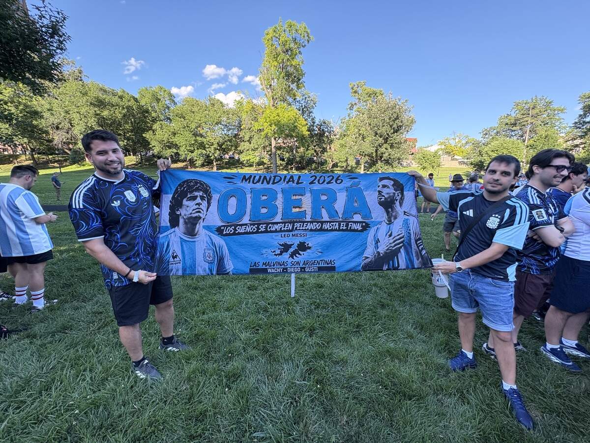 Diego Silva (left) and Gustavo Silva pose with their banner. The fans from Oberá traveled to Kansas City to watch Argentina in the FIFA World Cup. June 15, 2026.