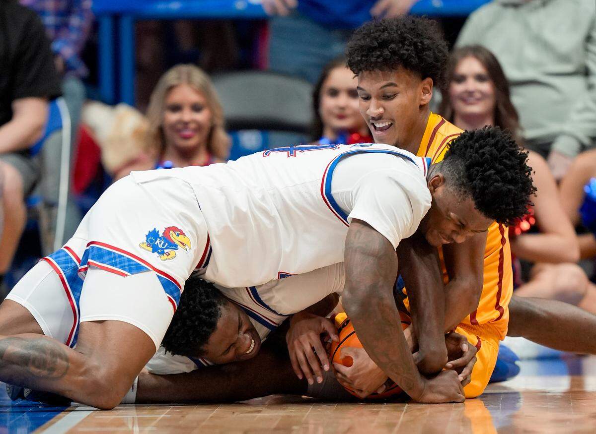 Kansas Jayhawks forwards KJ Adams Jr. (foreground) and Flory Bidunga (underneath Adams) fight Iowa State Cyclones guard Curtis Jones (behind, at top right) for a loose ball during a college basketball game at Allen Fieldhouse in Lawrence, Kansas, on Monday, Feb. 3, 2025.