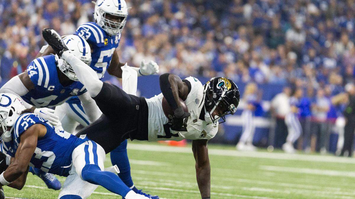 Jacksonville Jaguars running back Tank Bigsby (4) runs the ball while Indianapolis Colts cornerback Kenny Moore II (23) defends in the second quarter at Lucas Oil Stadium.