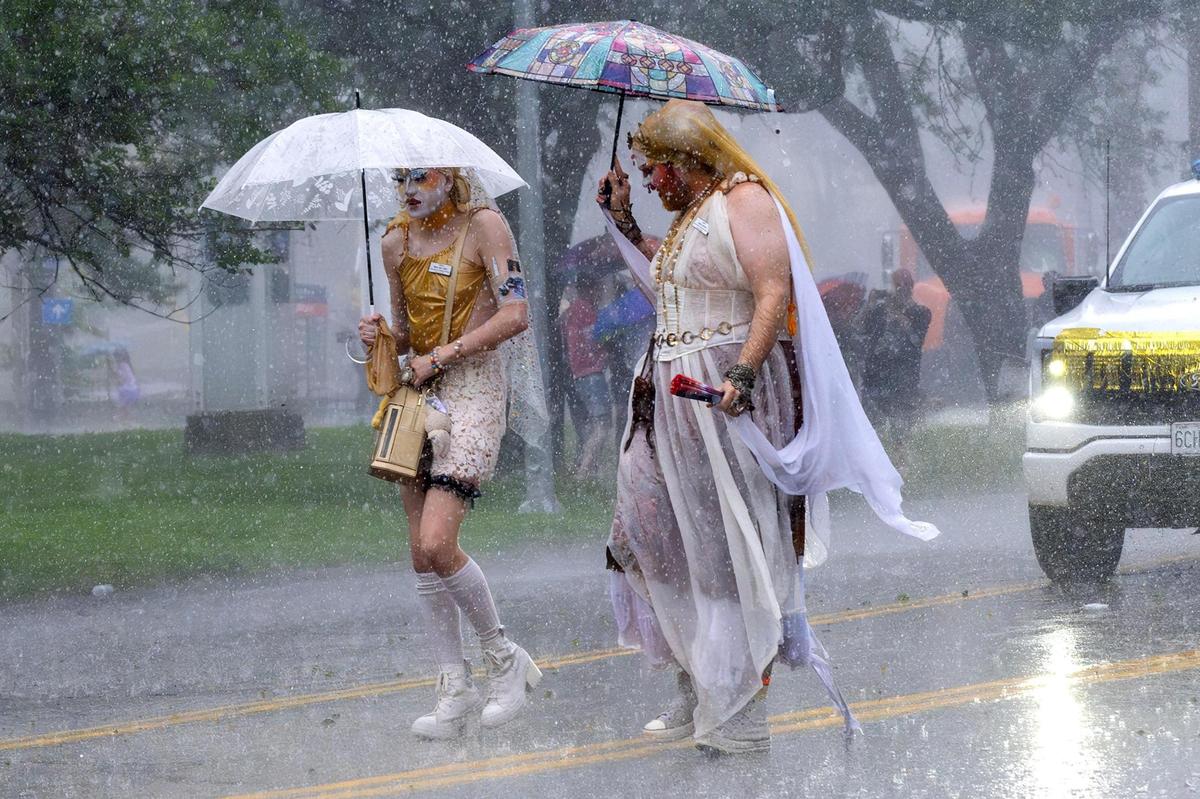 Heavy rain falls as parade participants continue walking along Mill Creek Parkway during the KC Pride Parade on Saturday, June 7, in Kansas City.