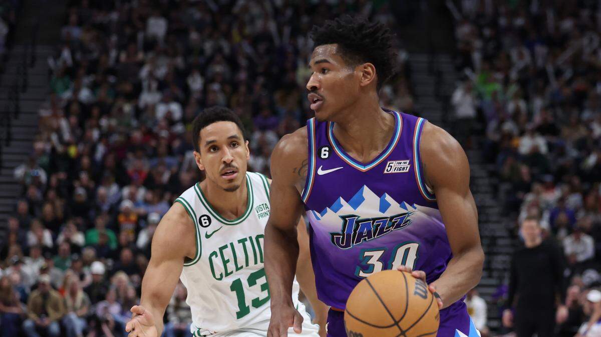 Utah Jazz guard Ochai Agbaji (30) dribbles past Boston Celtics guard Malcolm Brogdon (13) in the second half at Vivint Arena in Salt Lake City on March 18, 2023.