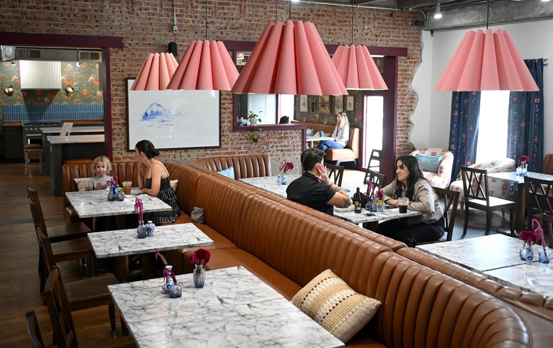 Customers converse in the middle room at Hemma Hemma. Starting Oct. 20, a cafeteria-style kitchen will serve hot and cold food in the space.