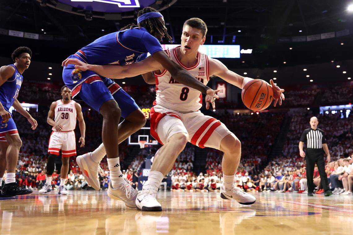 Ivan Kharchenkov #8 of the Arizona Wildcats posts up on Jamari McDowell #11 of the Kansas Jayhawks during the first half at McKale Center at ALKEME Arena on February 28, 2026 in Tucson, Arizona.
