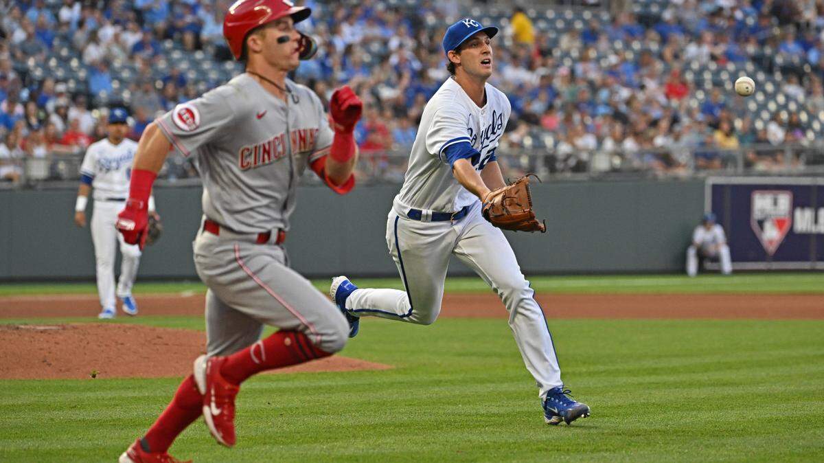 Cincinnati Reds second baseman Matt McLain, left, beats Daniel Lynch’s toss to first base during Wednesday night’s game at Kauffman Stadium.