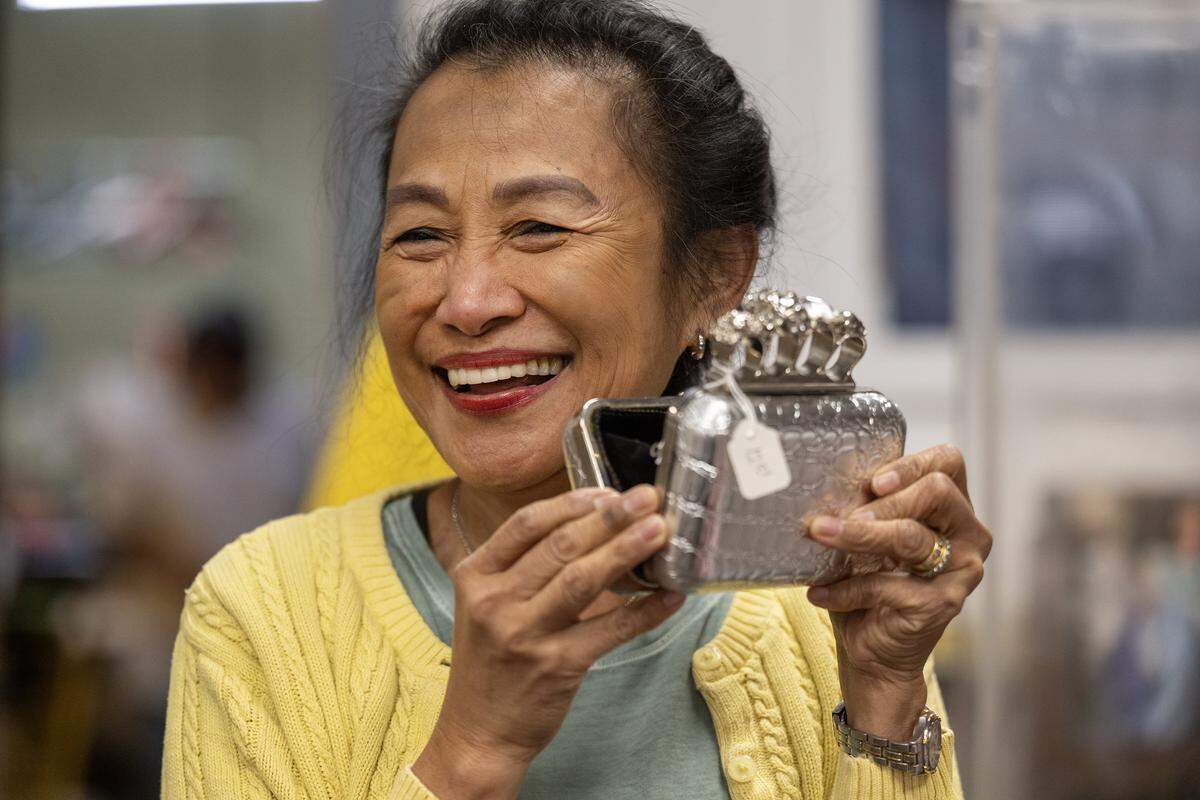 Jo Babaran, a founder/manager of Troost39, a thrift store at 3922 Troost Ave., laughs as she displays a vintage purse she priced at $12 on Thursday, Jan. 22 2026, in Kansas City.