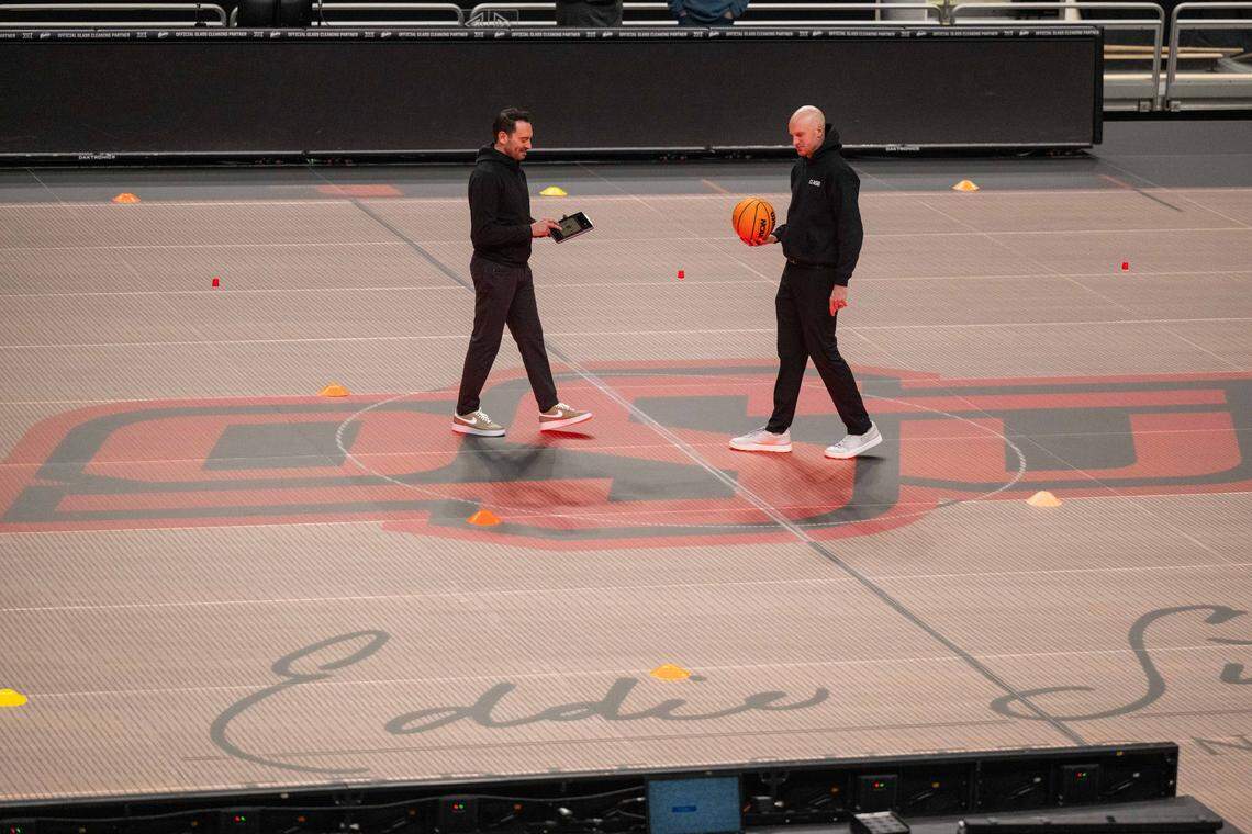 Chris Thornton, CEO of ASB Glassfloor, left, stands on the companies state-of-the-art glass LED basketball court, on Monday, March 2, 2026, at T-Mobile Center. The court is controlled through a tablet which is capable of changing the look of the court at the press of a button.