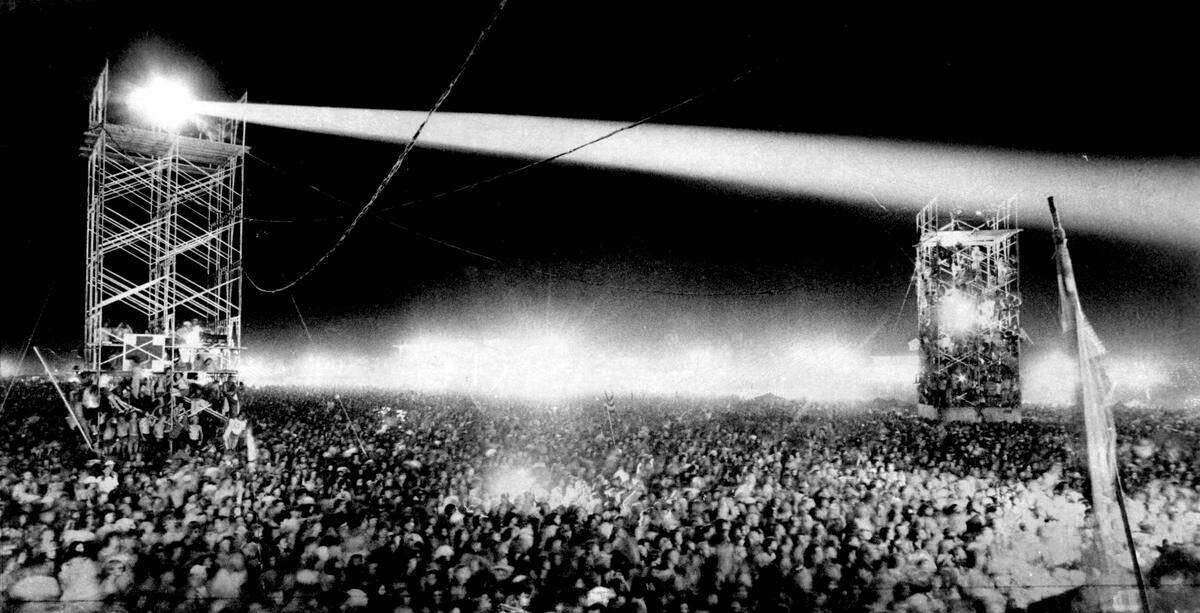Spotlights pierced the darkness over a crowd estimated at 60,000 people attending the first night of the Ozark Music Festival in Sedalia in 1974.