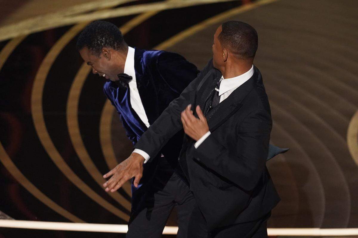 Will Smith, right, hit Chris Rock on stage as Rock presented the award for best documentary feature at the Oscars on Sunday at the Dolby Theatre in Los Angeles..