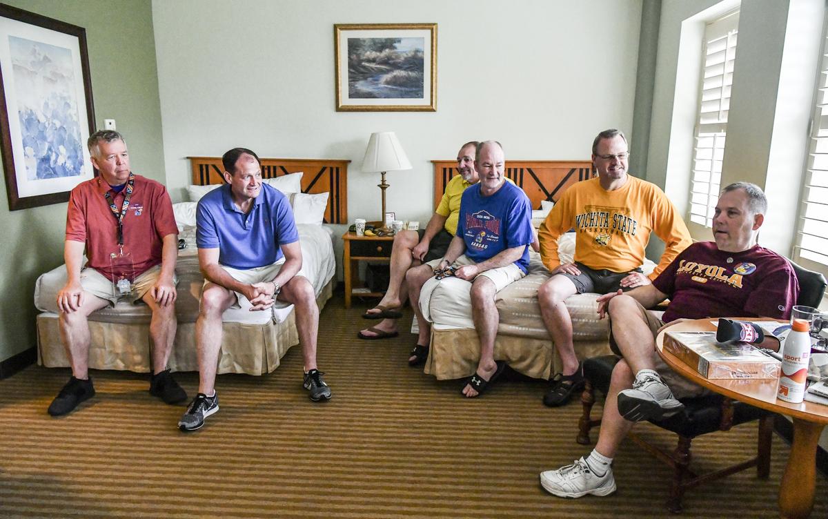 Christopher Korth of Kansas City (lower right) spoke on Saturday in his San Antonio, Texas, hotel room. Listening to Korth are (from left) Bren Abbott of Kansas City, Emmet Kenney of Fargo, N.D., Doug Knust of Chamberlain, S.D., Calvin Rider and Matt Heese of Wichita. The group of friends have consecutive Final Four streaks ranging from 15 to 30 years.
