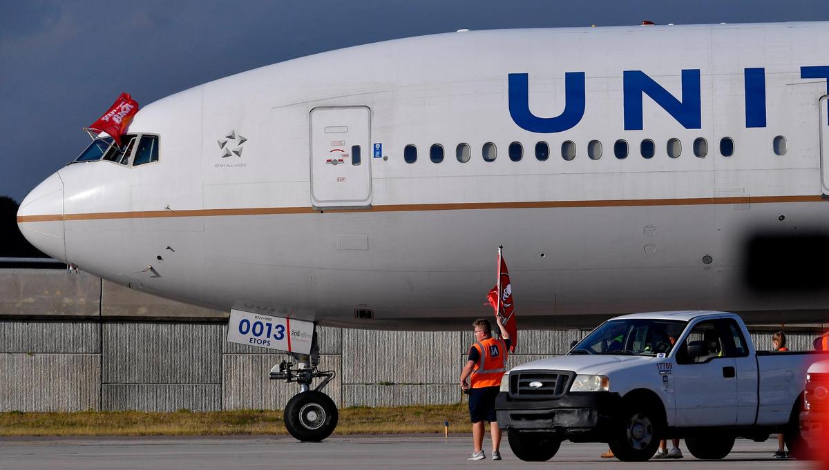 An employee at the Tampa International Airport got out of his pickup truck to wave a Tampa Bay Buccaneers flag just as the Kansas City Chiefs team plane arrived Saturday evening in Tampa. The Chiefs will take on the Buccaneers Sunday in Super Bowl LV.
