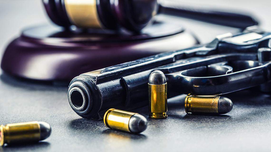 Judge’s hammer gavel. Justice and gun. Justice and the judiciary in the unlawful use of of weapons. Judgment in murder. firearm handgun pistol