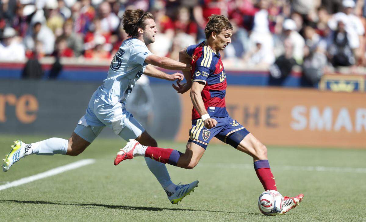 Real Salt Lake’s Sergi Solans, right, shoots past Sporting KC’s Ethan Bartlow during a Major League Soccer match at America First Field in Sandy, Utah on Saturday, April 4, 2026.