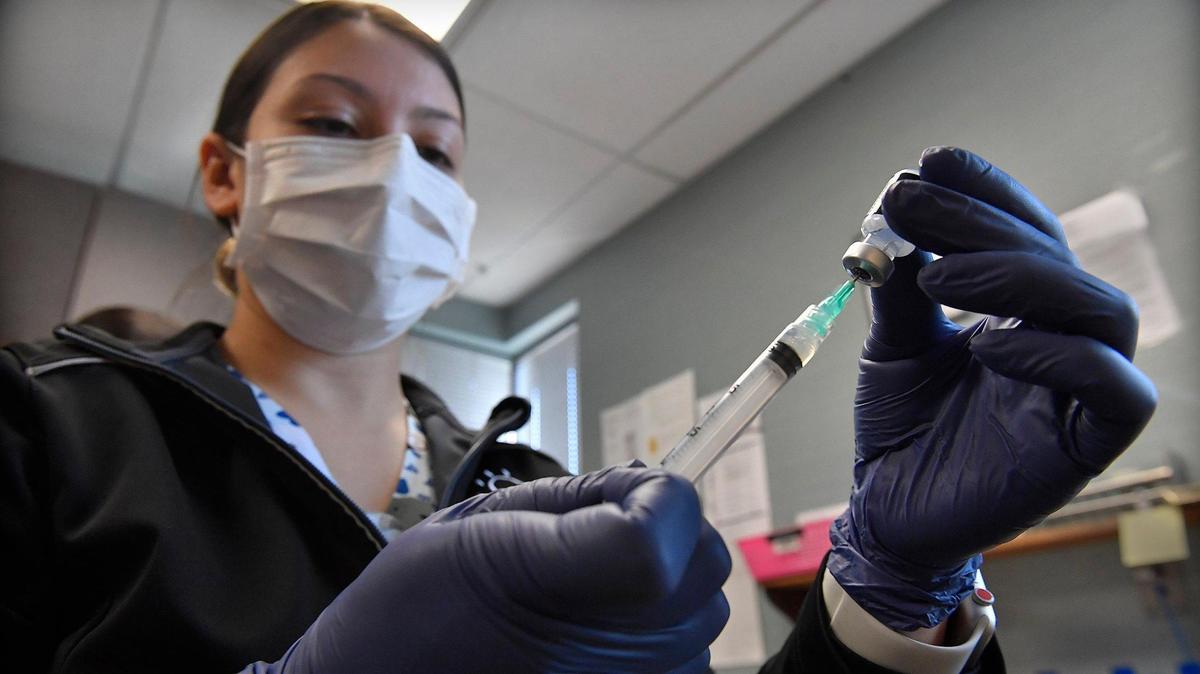 Breana Slusser, a medical assistant at Family Health Care KC, prepares a COVID-19 booster shot for a patient on Tuesday, Dec. 21, 2021, at the clinic in Kansas City, Kansas.