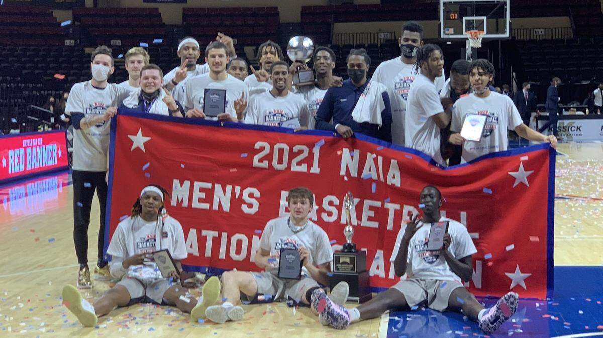 The Shawnee State Bears of Portsmouth, Ohio, pose with the 2021 NAIA national championship banner after beating Lewis-Clark State for the title Tuesday night in Kansas City.