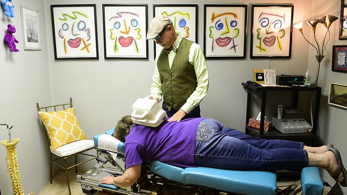 Dr. MooMoo, aka David McGee, treats his patient Linda Wagers in his Platte City chiropractic office.