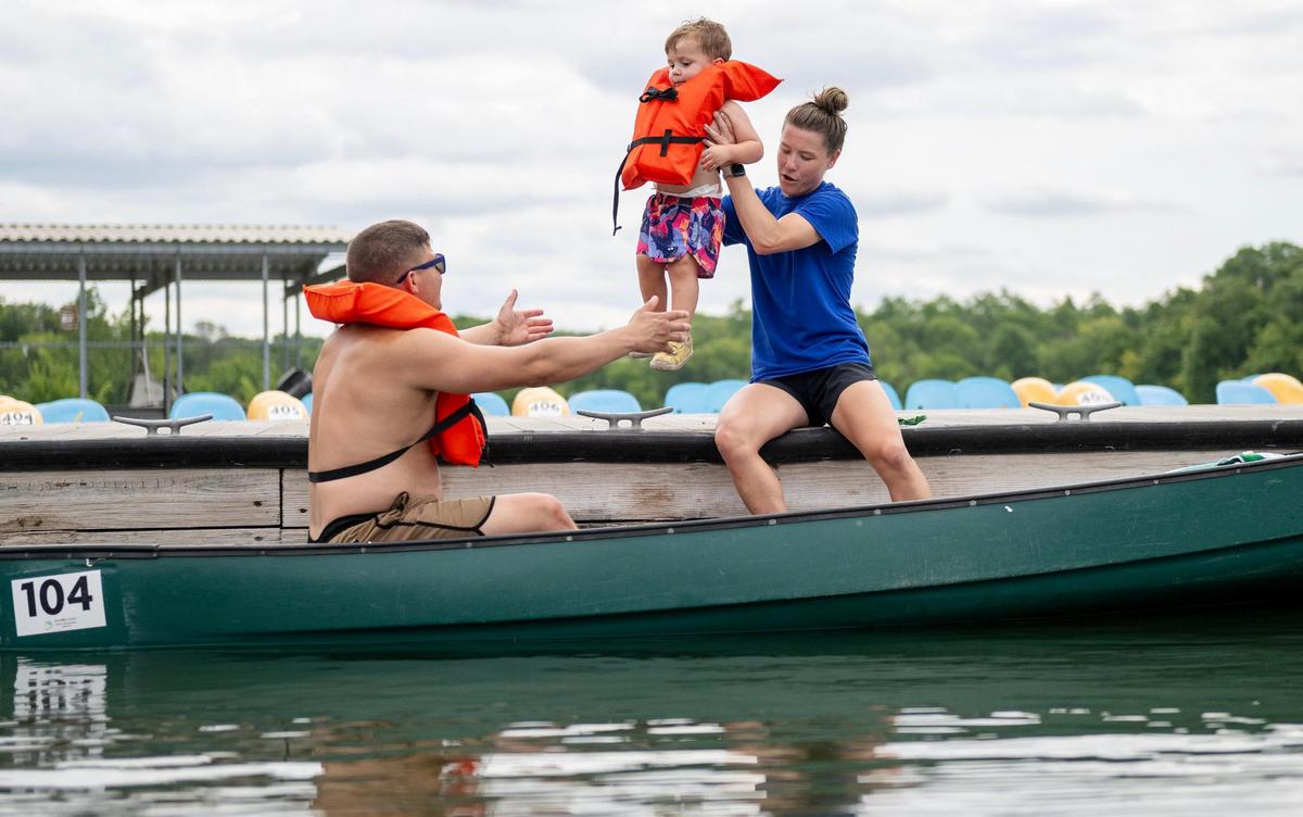 Paige Herrmann, an aquatics coordinator for the Johnson County Park and Recreation District, lifts Merlin Nielsen, 2, to his dad, Jeff, as they prepare to canoe at the newly-renovated marina at Shawnee Mission Park on Wednesday, July 12, 2023, in Shawnee, Kan.