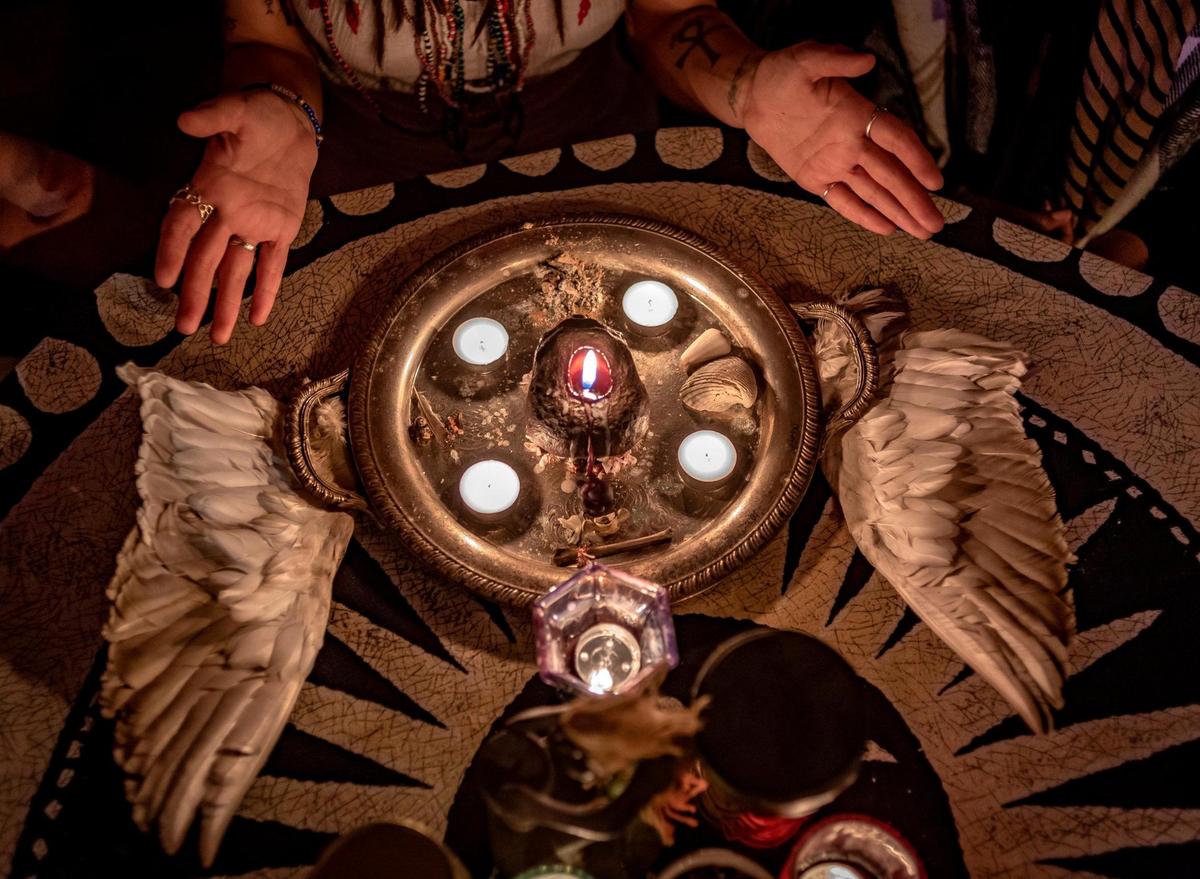 Nicolette Paige prays to the spirits of her ancestors during a new moon ceremony. The eagle feathers were a gift from a Native American.