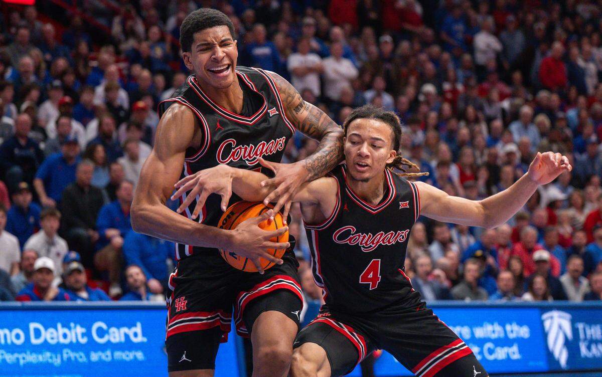 Houston Cougars guard Kingston Flemings (4) and center Chris Cenac Jr. (5) fight for a loose ball in the second half against the Kansas Jayhawks on Monday, February 23, 2026, at Allen Fieldhouse.