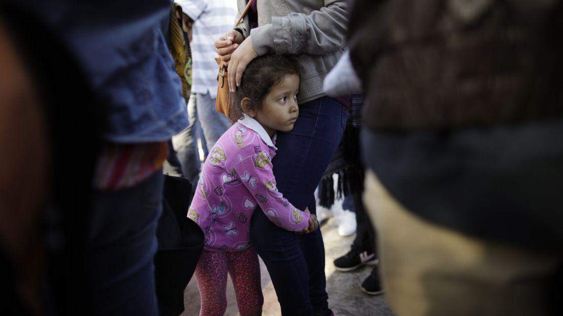 Nicole Hernandez, of the Mexican state of Guerrero, holds on to her mother as they wait with other families to request political asylum in the United States.