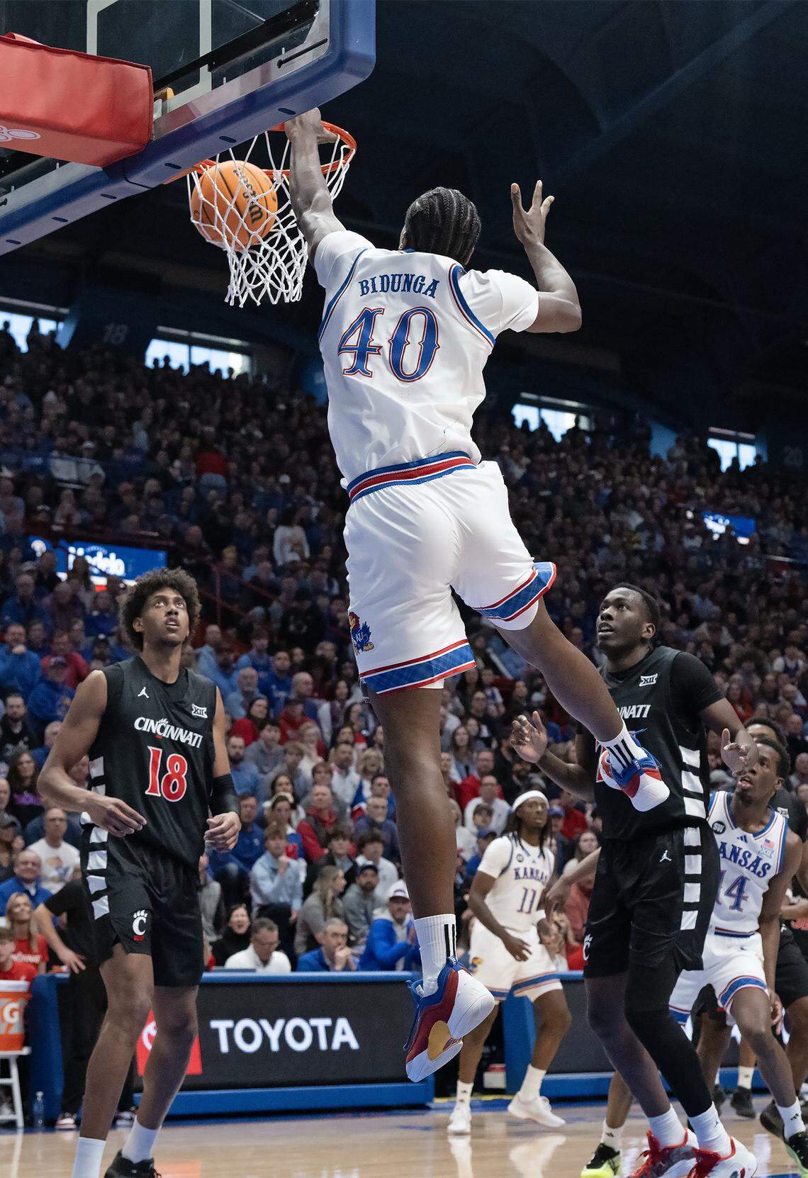 Kansas Jayhawks forward Flory Bidunga (40) slams it home as Cincinnati Bearcats forward Baba Miller (18) looks on in the first half Allen Fieldhouse on Saturday, Feb. 21, 2026, in Lawrence, Kansas.