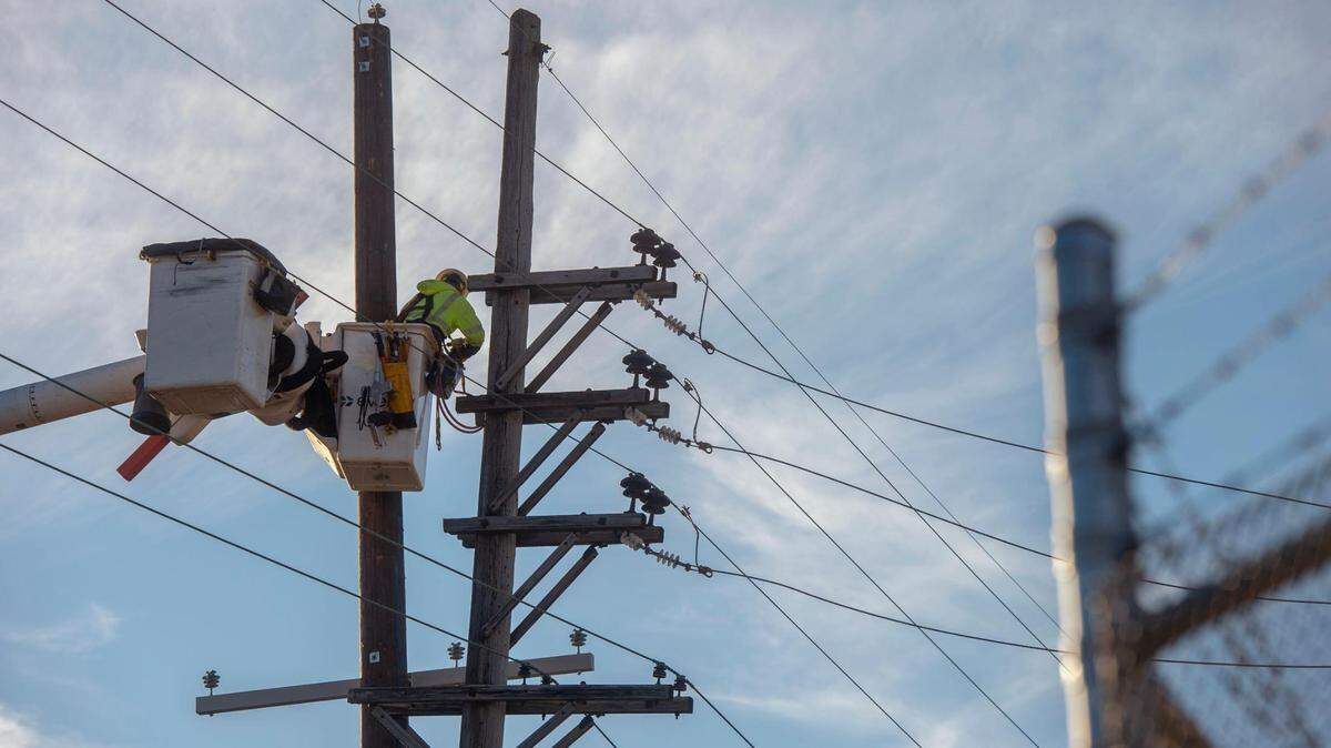 A Evergy crew member repairs a damaged electricity pole at West 25th St. in Kansas City, Missouri on Thursday, Dec. 16, 2021. The damage comes a day after Kansas City experienced a severe thunderstorm.