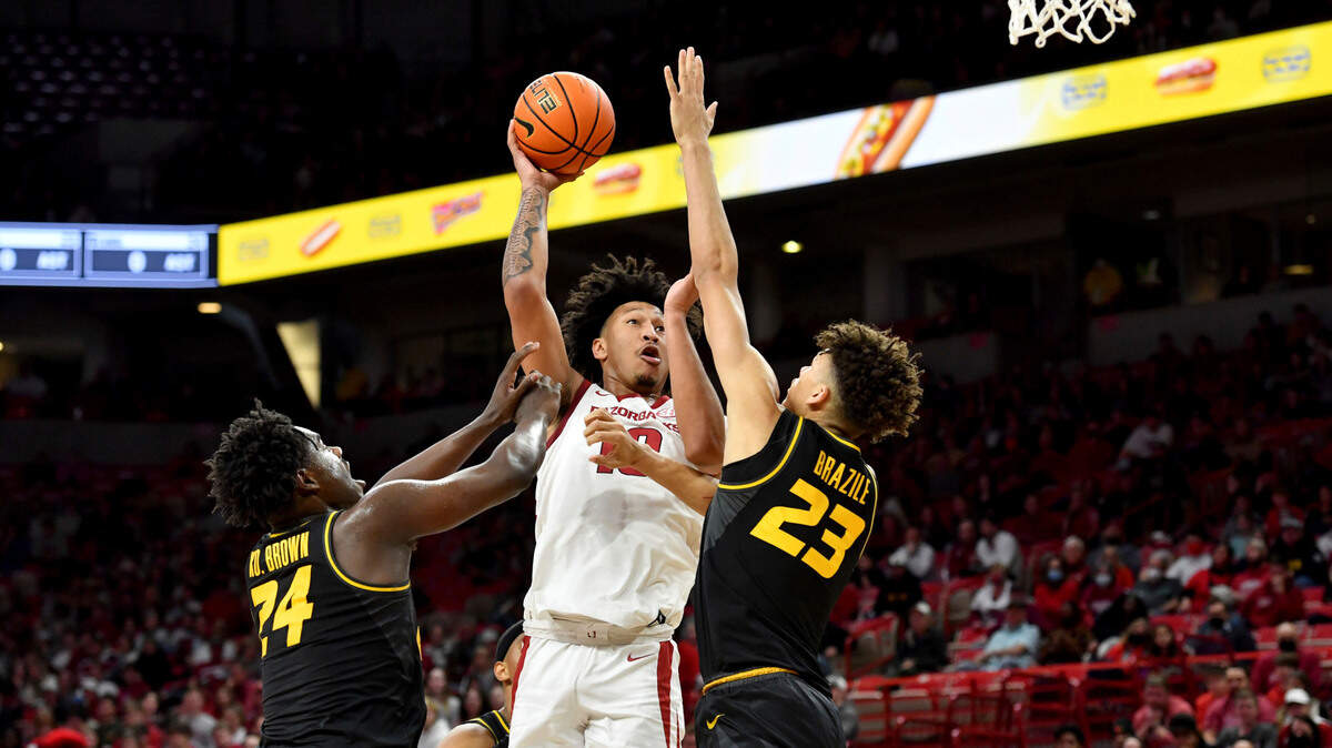 Arkansas forward Jaylin Williams (10) tries to shoot over Missouri defenders Kobe Brown (24) and Trevon Brazile (23) during an NCAA college basketball game Wednesday, Jan. 12, 2022, in Fayetteville, Ark. (AP Photo/Michael Woods)