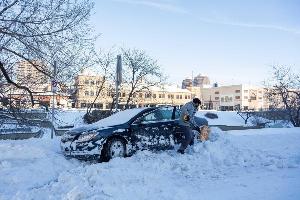 Prabhat Sai Rao works to dig out his car outside his apartment near the Country Club Plaza in Kansas City on Monday, Jan. 6, 2025.